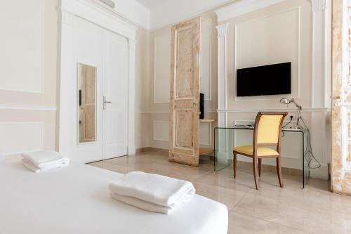 a bedroom with a desk and a bed and a chair at Napolit'amo Hotel Principe in Naples