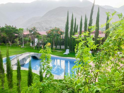 einen Pool in einem Garten mit Bergen im Hintergrund in der Unterkunft Casa Hotel Mamaluna in Lunahuaná