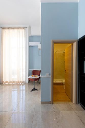 a room with a door and a table and a chair at Napolit'amo Hotel Principe in Naples