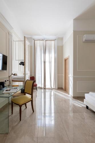 a large living room with a table and a couch at Napolit'amo Hotel Principe in Naples