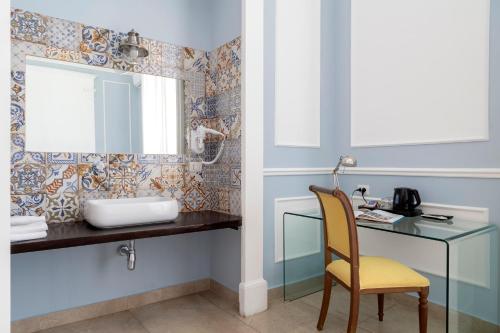 a bathroom with a desk and a mirror at Napolit'amo Hotel Principe in Naples