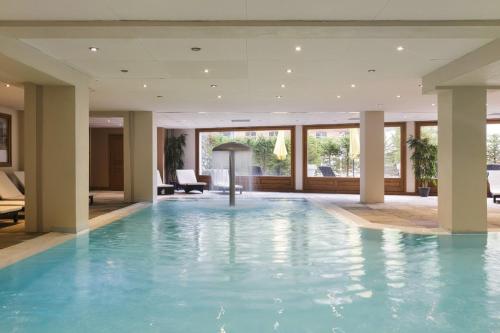 une grande piscine dans le hall de l'hôtel dans l'établissement Loriaz 12 - Appartement avec vue et piscine à deux pas du telecabine, à Vallorcine
