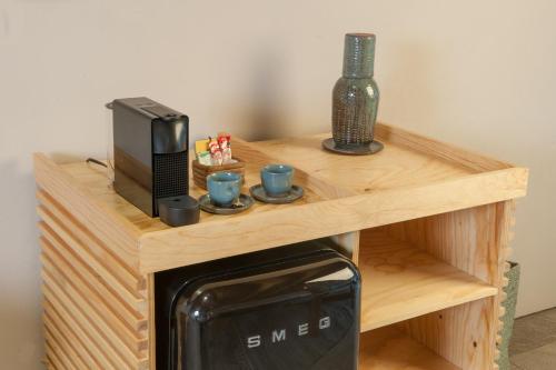 a small wooden table with a microwave and coffee cups at El Lugar del que te hable Hotel Boutique in Valle de Bravo