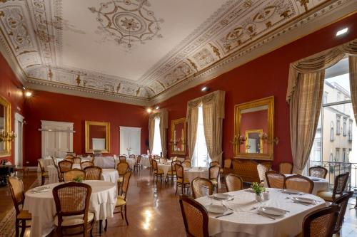 jadalnia ze stołami i krzesłami oraz sufitem w obiekcie Napolit'amo Hotel Principe w mieście Neapol