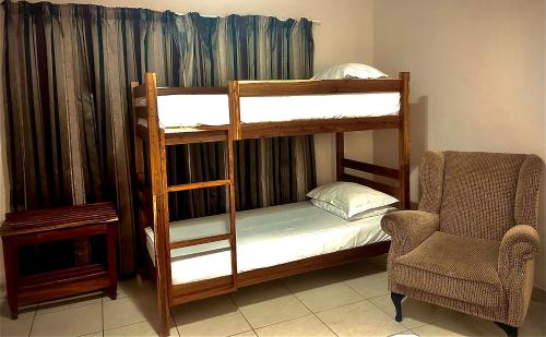 a room with two bunk beds and a chair at Casa Calida Guest House in Upington