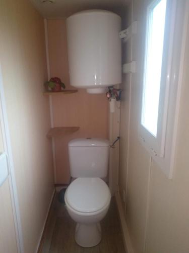 a small bathroom with a toilet and a window at Couette et Tartinettes in Bretagne-dʼArmagnac