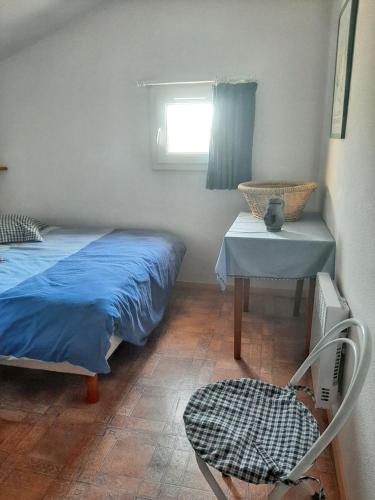 um quarto com uma cama, uma mesa e uma cadeira em Maison de 2 chambres avec piscine partagee jardin clos et wifi a Eyguieres em Eyguières