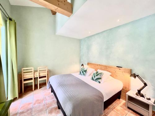 a bedroom with a bed and a table and chairs at Logis Hôtel Restaurant Le Domaine de l'Eau Vive in Largentière