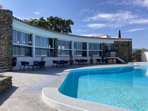 - une piscine en face d'un bâtiment avec une maison dans l'établissement Le jardin suspendu, à Collioure