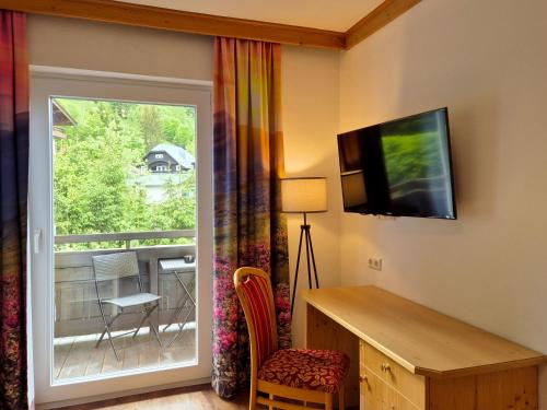 a room with a sliding glass door leading to a balcony at Alpenpension Gastein in Bad Gastein