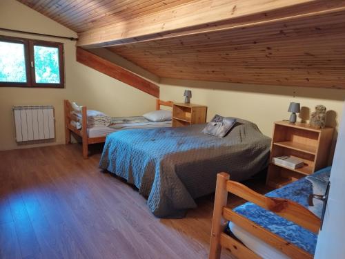 une chambre avec deux lits et un plafond en bois dans l'établissement Bel appartement proche Saint Lary Soulan, à Vielle-Aure