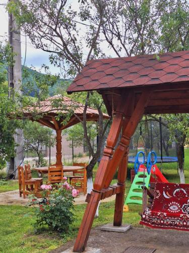a playground with a swing set and a play area at Pensiunea Casa Ancuta in Vadu Izei