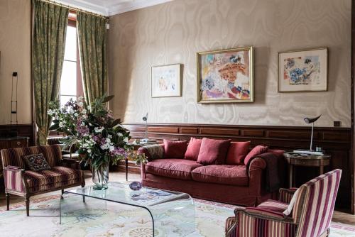 a living room with a red couch and chairs at Château Sénéjac in Le Pian-Médoc