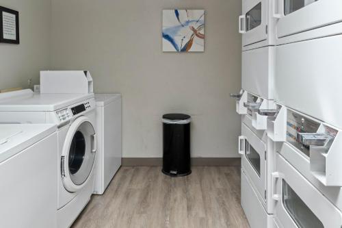 a white laundry room with a washer and dryer at Candlewood Suites Port Arthur/Nederland by IHG in Nederland