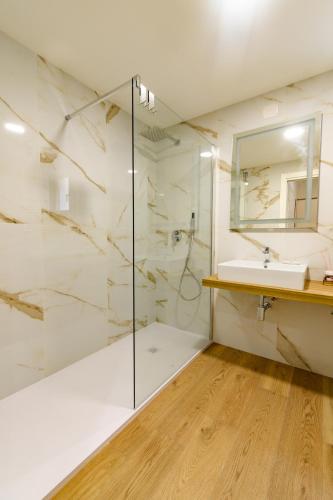a bathroom with a glass shower and a sink at Harbor Rooms - Cala Gonone in Cala Gonone