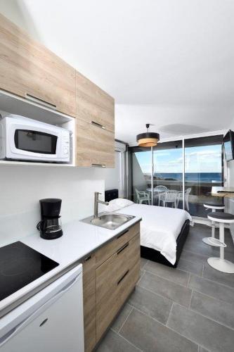 - une cuisine avec évier et un lit dans une chambre dans l'établissement Studio Horizon - Héliopolis AB 408 - Luxe - 2 personnes, au Cap d'Agde