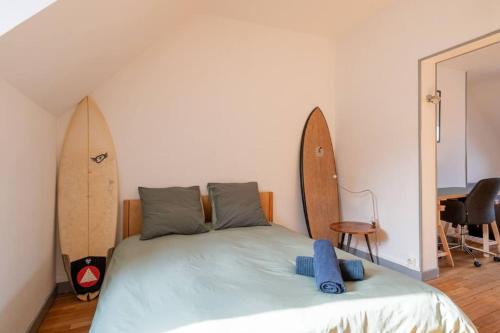 - une chambre avec un lit et une planche de surf sur le mur dans l'établissement Amiens - Appartement vue Cathédrale, à Amiens