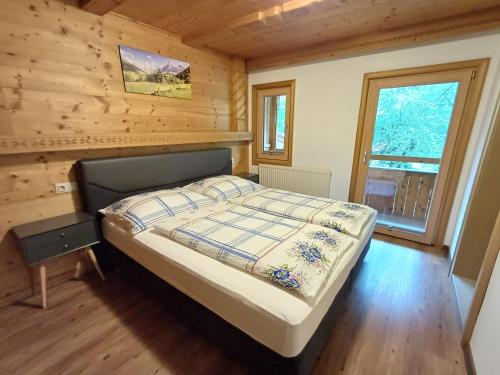 a bedroom with a bed in a wooden cabin at Landhaus Eberler in Mayrhofen