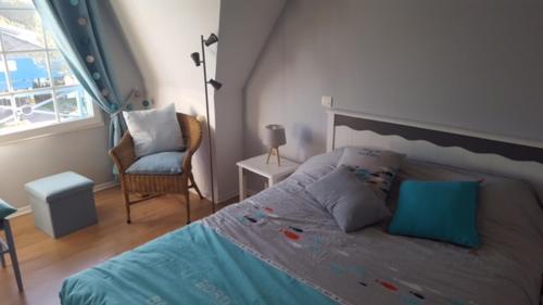 ein Schlafzimmer mit einem Bett, einem Stuhl und einem Fenster in der Unterkunft BELLE DUNE Village Vacances face à l'Aquaclub de FORT MAHON in Fort-Mahon-Plage