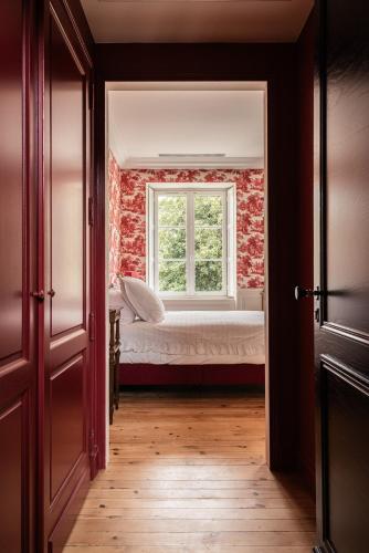 a bedroom with a bed and a window at Château Sénéjac in Le Pian-Médoc