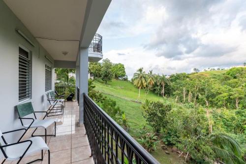 a balcony with chairs and a view of a field at Enjoy Rare Huge POOL 4br Perfect for Families! in Aguada