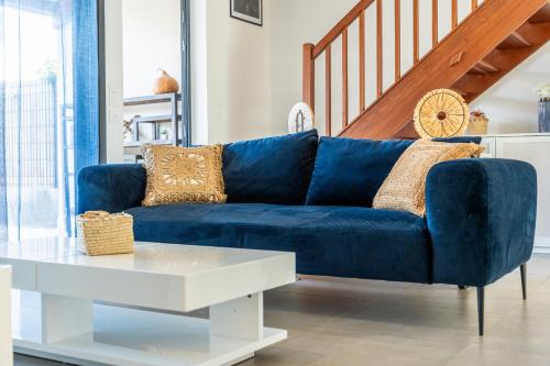 un sofá azul en una sala de estar con una mesa blanca en Villa Nueva Meublé de tourisme 3 étoiles Piscine Privée, en Saint-Pierre