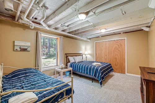 Un dormitorio con dos camas y una ventana. en Charming Pentwater Home with Fire Pit and Yard!, en Pentwater