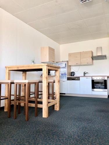a kitchen with a wooden table in a room at Kobra Room, 4 Personen in Spielberg