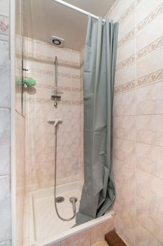 une douche avec un rideau de douche dans une salle de bain dans l'établissement Sublime appartement, à Champlan