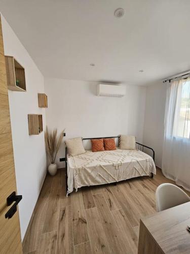 une chambre avec un lit dans une pièce blanche dans l'établissement Maison proche des Calanques de la Côte Bleue, à Ensuès-la-Redonne