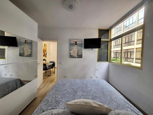 2 Bedrooms Flat 50 mts away from Las Canteras beach في لاس بالماس دي غران كاناريا: غرفة نوم بسريرين ونافذة