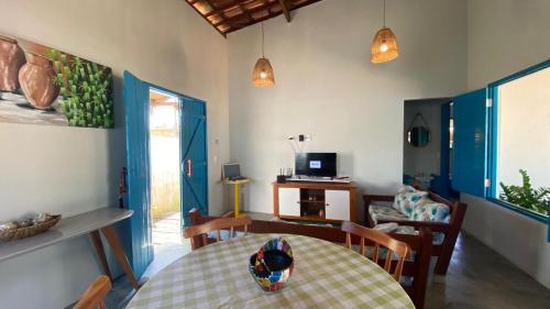 - un salon avec une table, des chaises et une télévision dans l'établissement Pousada Vila Lua Bela, à Pitimbu