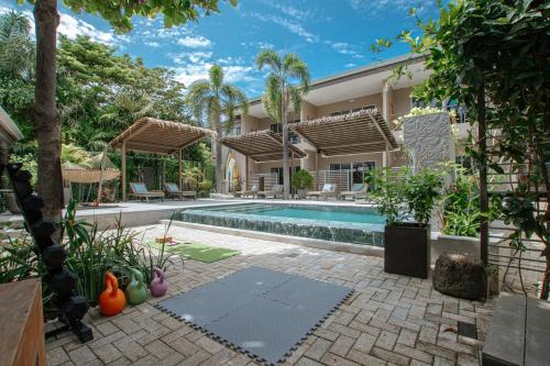an exterior view of a house with a swimming pool at Tamarindo Bay Boutique Hotel, Apartments & Suites in Tamarindo