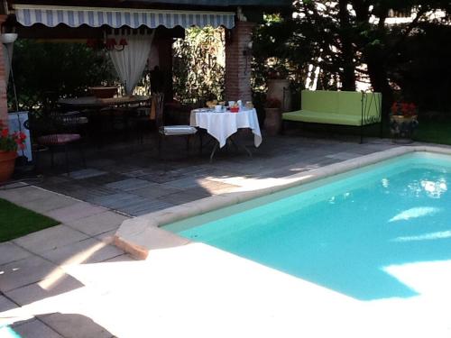 una piscina con una mesa, una mesa y una mesa en Villa du Canal, en Toulouse