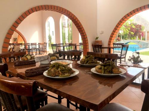 a long wooden table with plates of food on it at Casa Hotel Mamaluna in Lunahuaná