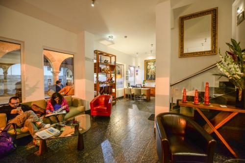 two people sitting on couches in a living room at Hotel Plaza de Armas Cusco in Cusco