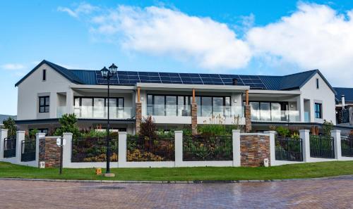 a house with solar panels on the roof at The Peaks - Kingswood Golf Estate in George