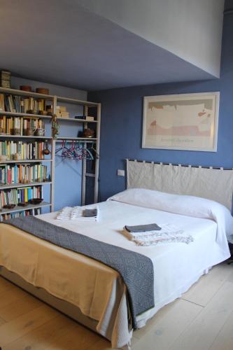 a bedroom with a large white bed with bookshelves at Verdemare e Verdementa in Portovenere