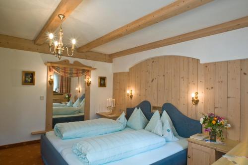 a bedroom with a blue bed with a mirror at Alpenhotel Fernau in Neustift im Stubaital