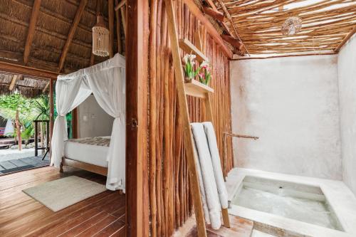 a room with a bed and a room with a door at Xhule Tulum in Tulum