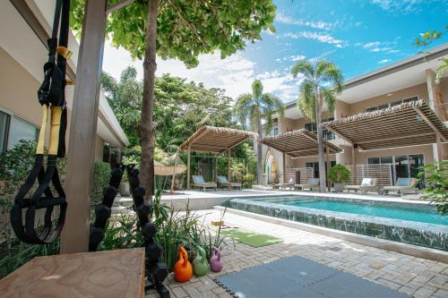 an exterior view of a house with a swimming pool at Tamarindo Bay Boutique Hotel, Apartments & Suites in Tamarindo