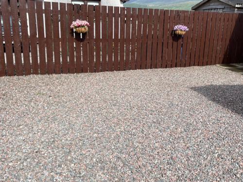 two potted plants on a wooden fence at Riverside Retreat in Caol