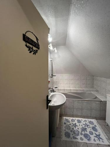 une salle de bain avec un lavabo et une baignoire dans l'établissement Appartement à la campagne, à Bournainville