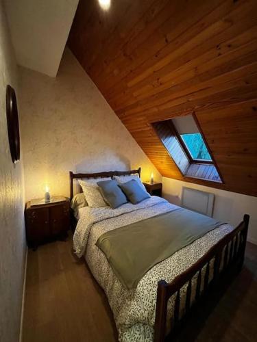 a bedroom with a large bed in a attic at Appartement à la campagne in Bournainville