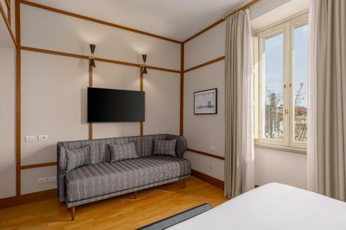 a living room with a couch and a flat screen tv at Room Mate Luca, Florence in Florence