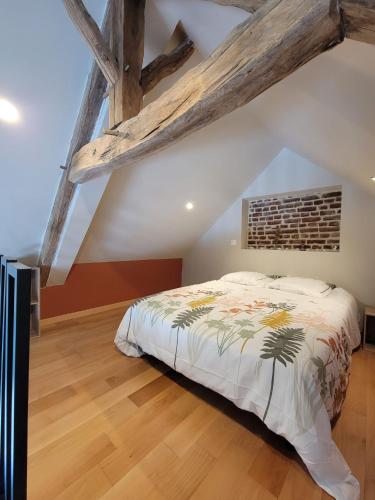 une chambre avec un lit dans un grenier dans l'établissement La Mésange bleue, à Ognes