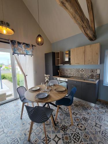 une cuisine avec une table et des chaises dans une pièce dans l'établissement La Mésange bleue, à Ognes