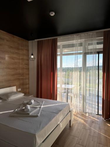 a bedroom with a bed and a large window at Modern House in Solotvyno