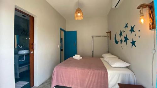 a bedroom with a bed with stars on the wall at Pousada Vila Lua Bela in Pitimbu