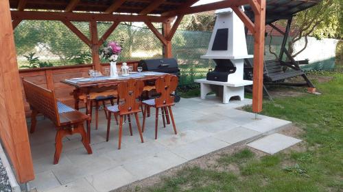 a patio with a table and chairs and a stove at Chalupa - Dešov in Desov